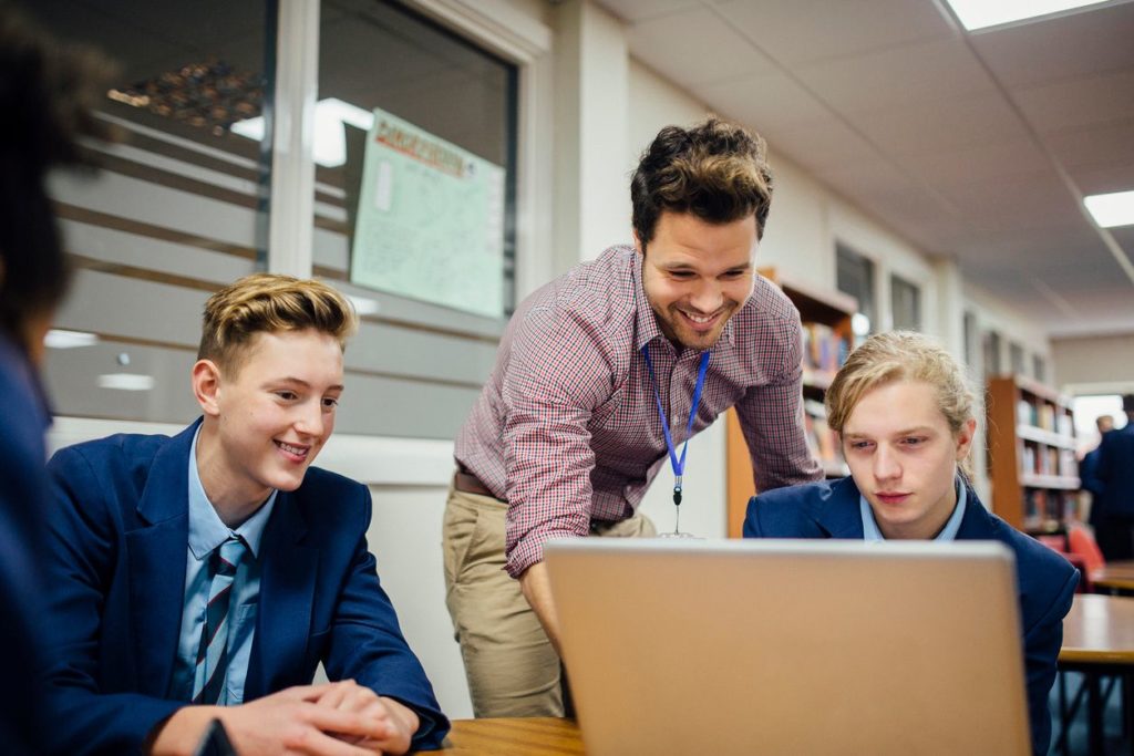 Three young men looking at a computer